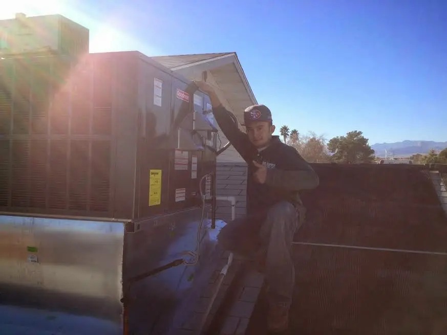 HVAC technician performing HVAC Inspection on a rooftop unit in Urbana
